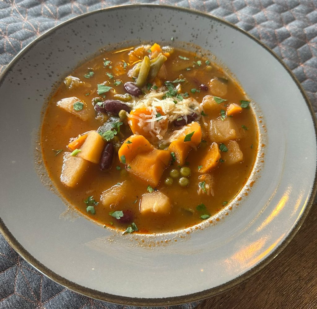 Hausgemachte Minestrone mit Gemüse, Bohnen und geriebenem Parmesan